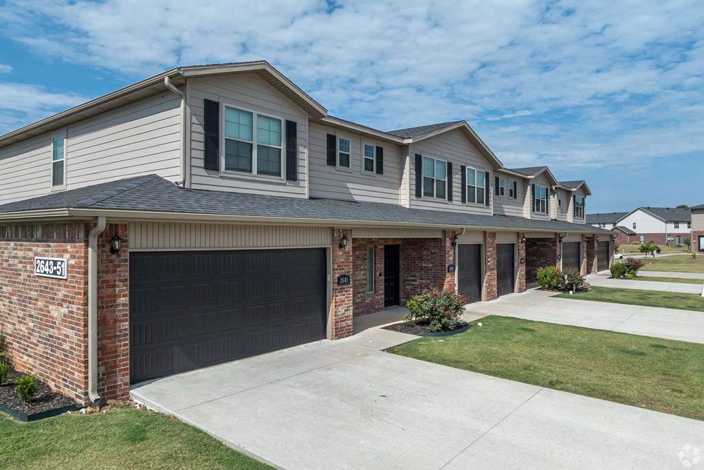 A row of houses with garages and driveways.