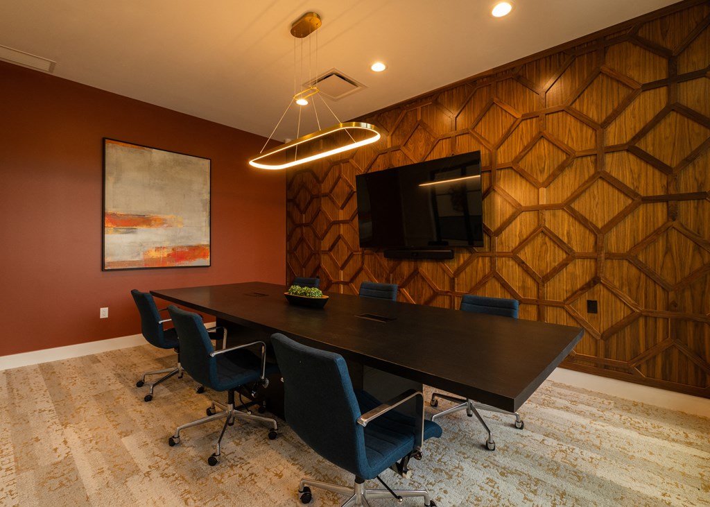 a conference room with a table and chairs and a tv a conference room with a table and chairs and a tv at The Clearing at ONE28, Olathe, KS