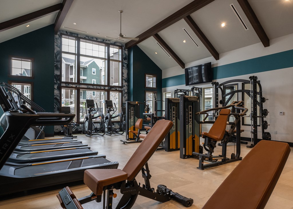 a gym with treadmills and other exercise equipment and a large window  at The Clearing at ONE28, Olathe, Kansas