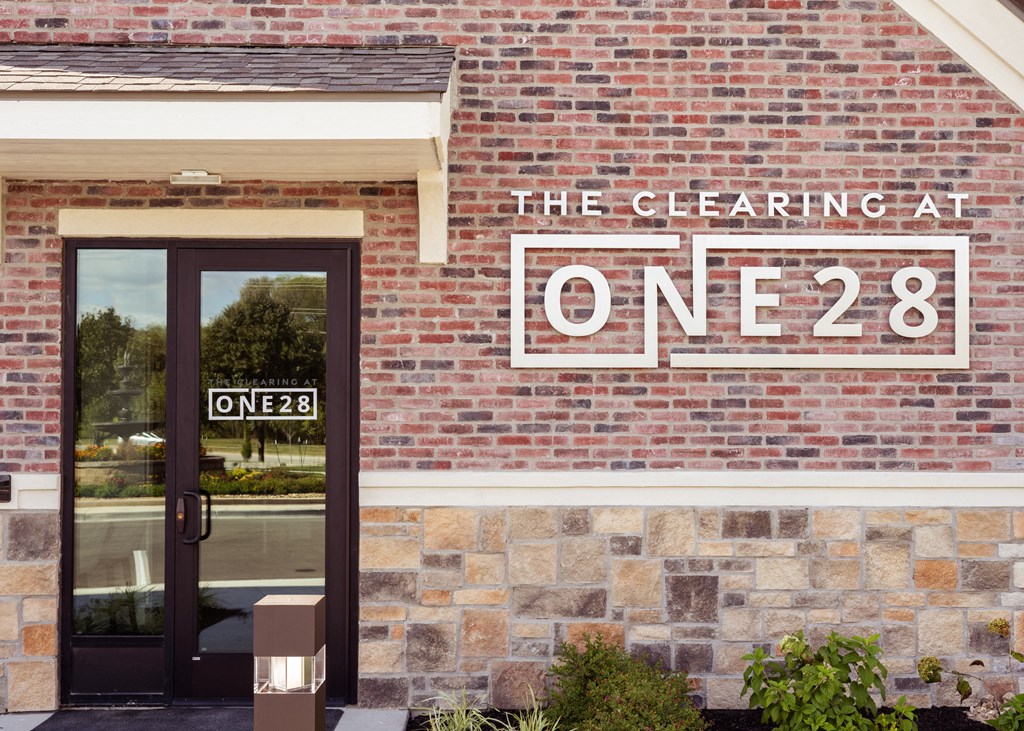 the facade of a brick building with a sign that reads the clearing at one 82  at The Clearing at ONE28, Olathe, Kansas