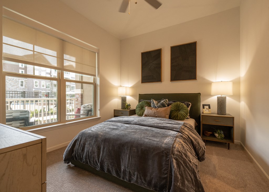 a master bedroom with a large window and a bed  at The Clearing at ONE28, Olathe, KS, 66062