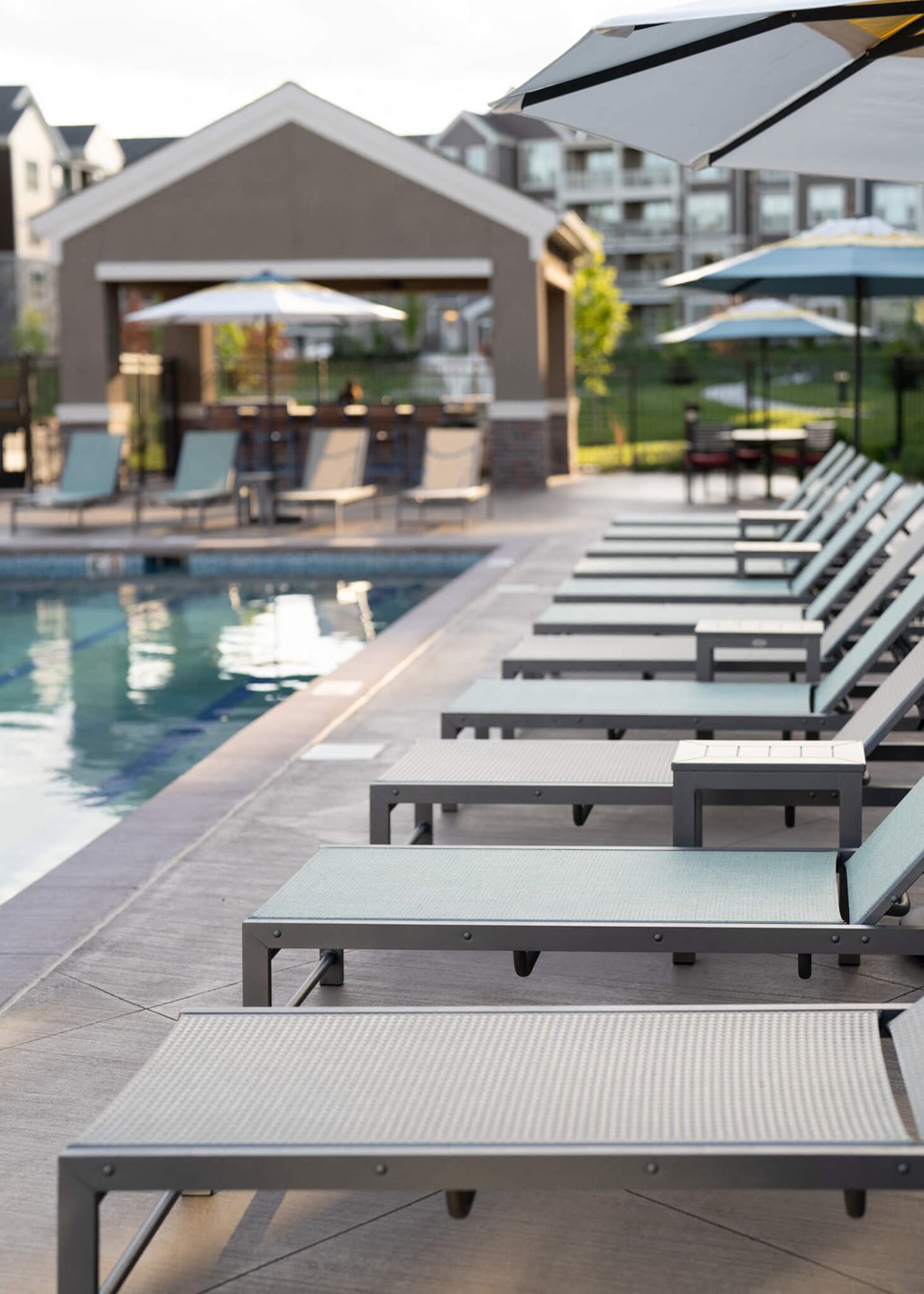 a row of lounge chairs next to a pool