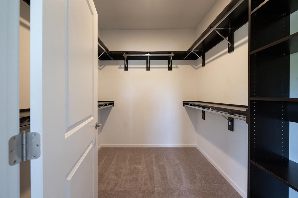 a walk in closet with empty shelves and empty belts