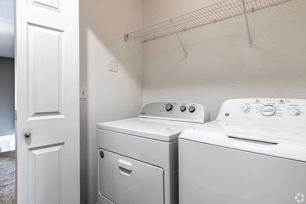 A white dryer and washer in a small laundry room.