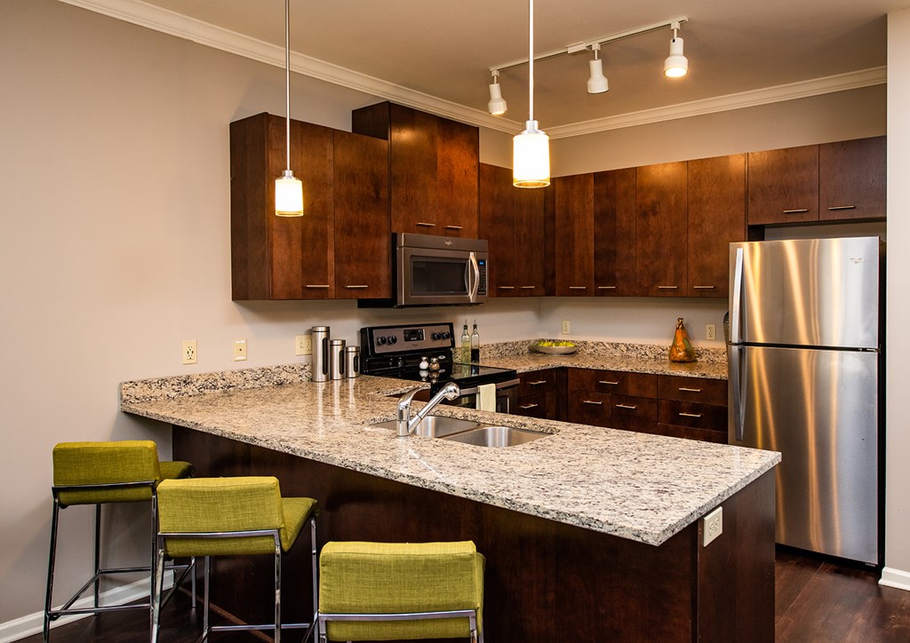 A kitchen with a granite countertop and stainless steel appliances.