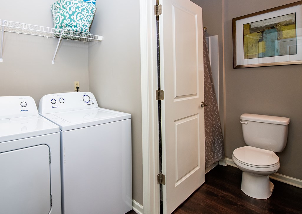 A small laundry room with a toilet and washer.