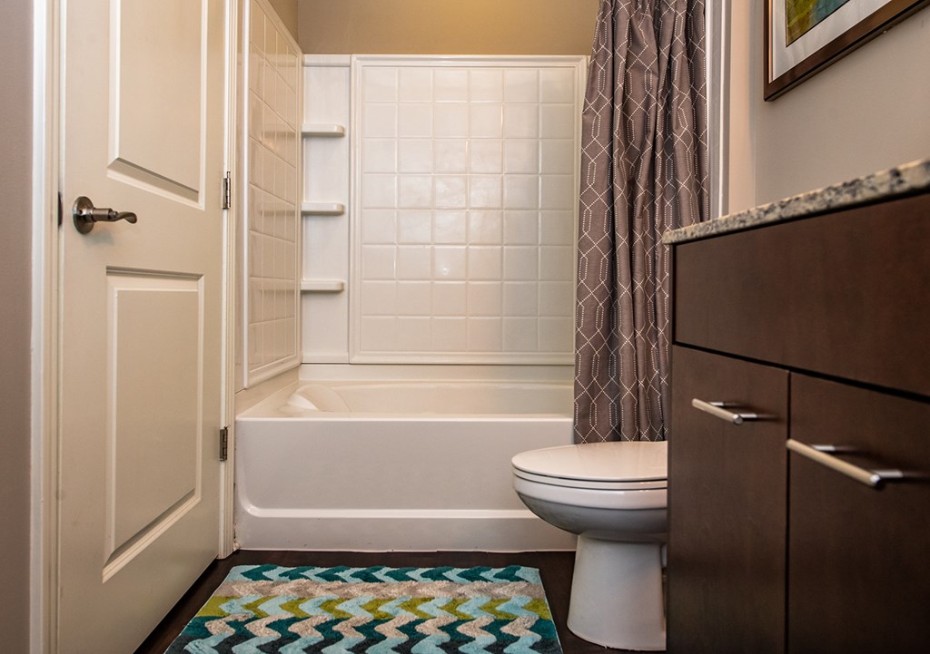 A bathroom with a toilet, tub, and sink.