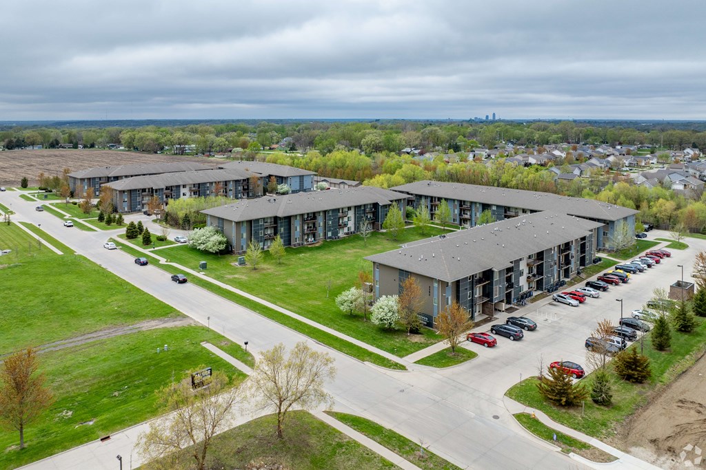 A large apartment complex with a parking lot in front.