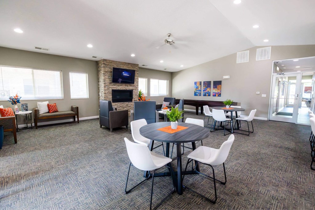 A conference room with a table, chairs, and a television on the wall.