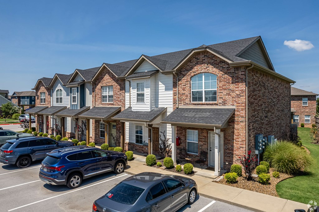 a row of houses with cars parked in front of them