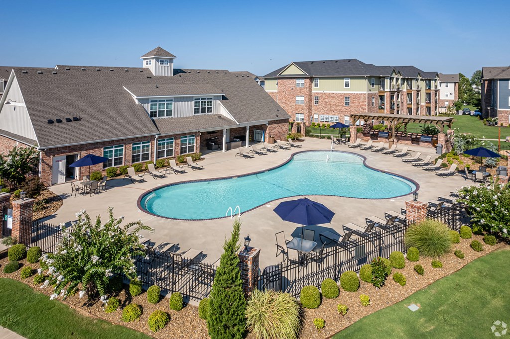 an aerial view of a swimming pool with a resort style building