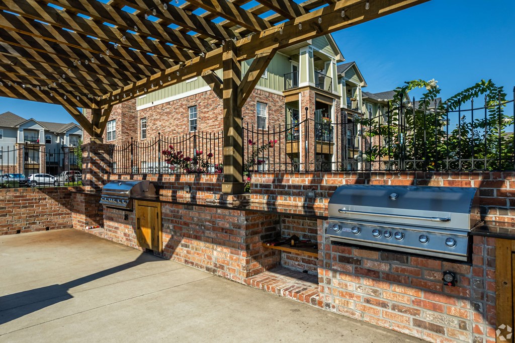 a backyard with a barbecue grill and a brick wall