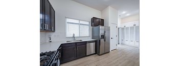 A kitchen with a stove top oven and a refrigerator.