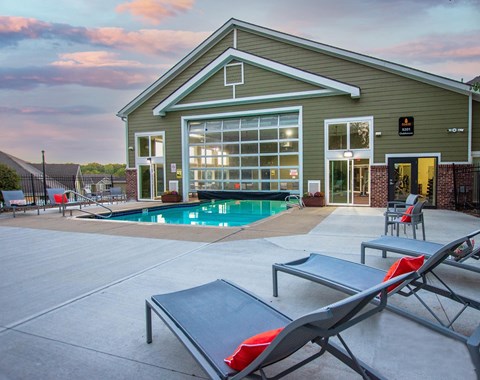 A poolside lounge area with sunbeds and a building in the background.