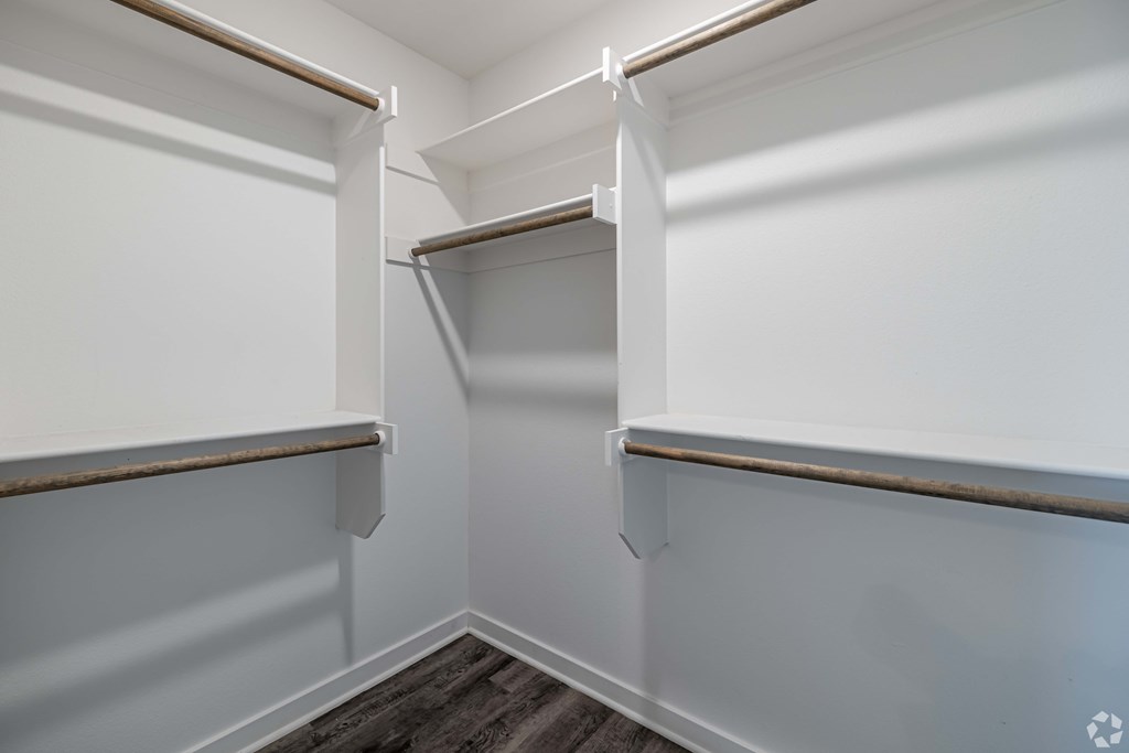 A white pantry with a wood shelf and a recycling symbol on the floor.