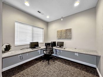 A room with two desks and a computer on each.