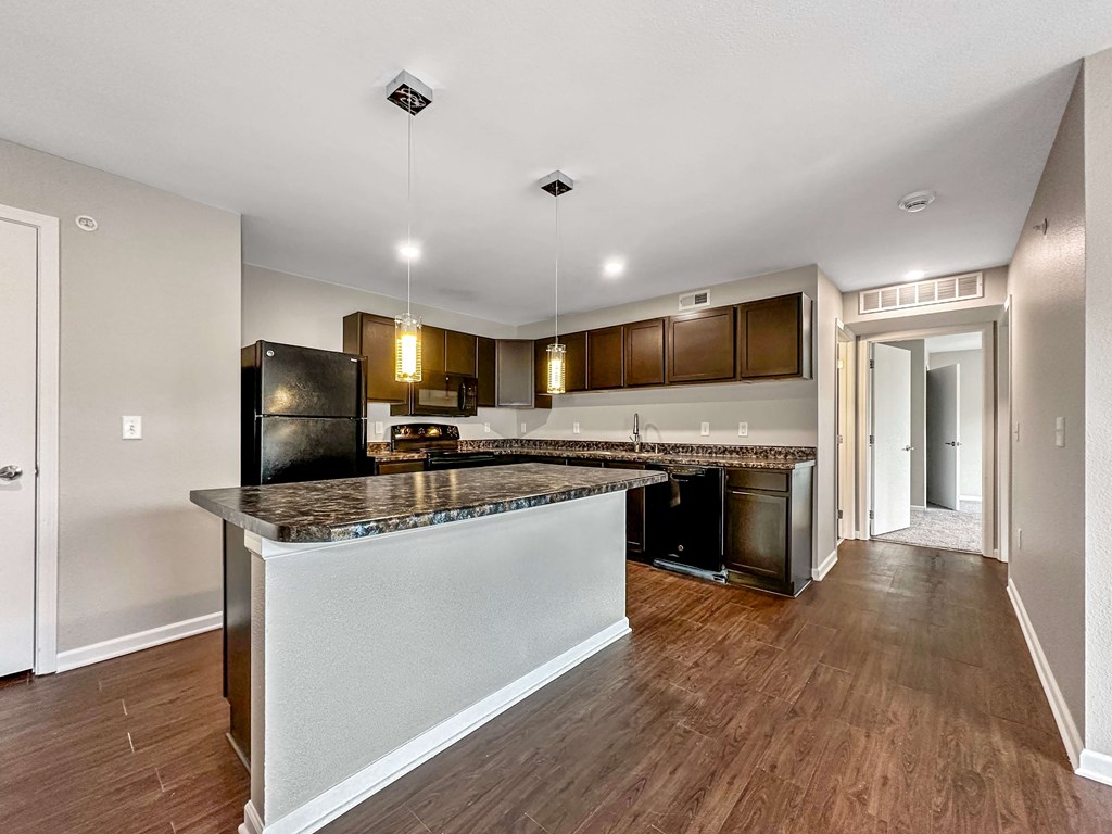 A kitchen with a granite countertop and a refrigerator.