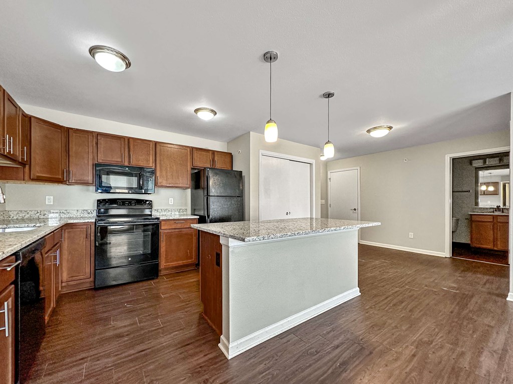 A kitchen with wooden cabinets and a black oven.