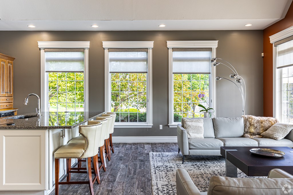 A well-lit, modern kitchen with a bar area and a seating area.