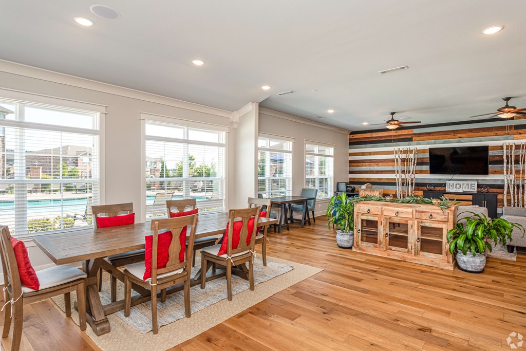 a dining room with a table and chairs and a living room with windows
