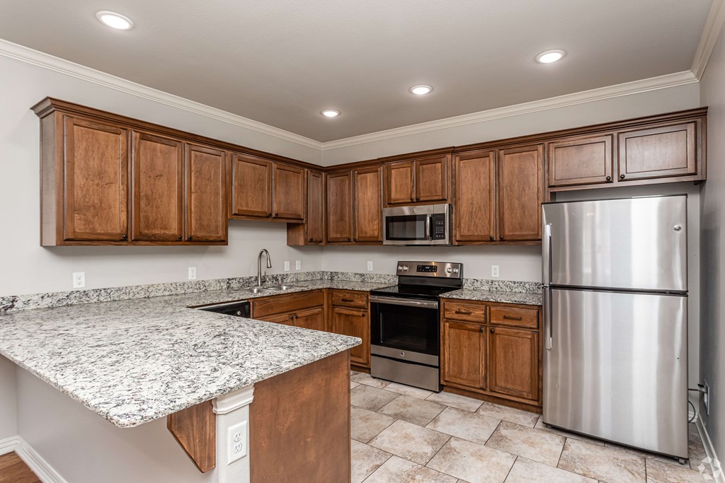 a kitchen with wooden cabinets and granite counter tops and stainless steel appliances