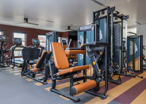 A gym with a row of exercise machines.