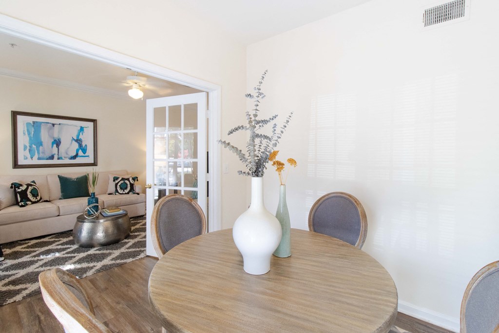 A dining table with a vase and a plant on it. at The Crest at Sugarloaf, Georgia