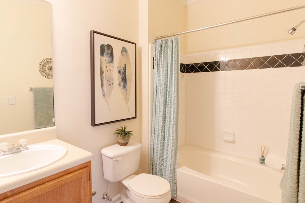 A bathroom with a toilet, sink, and bathtub. at The Crest at Sugarloaf, Lawrenceville, GA