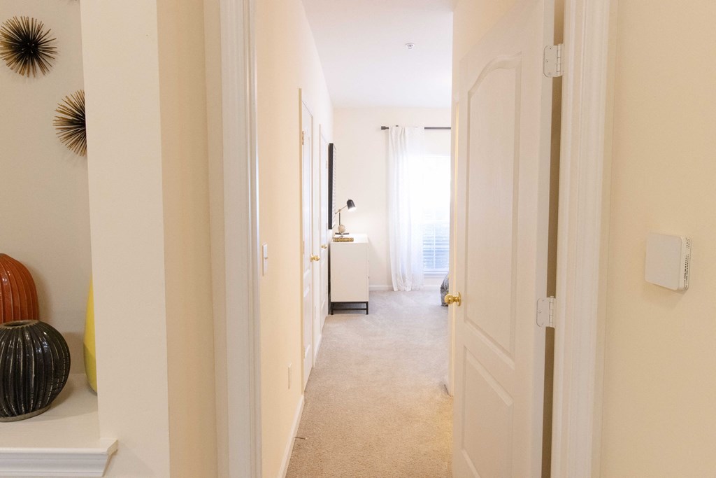 A hallway with a white door and a white wall. at The Crest at Sugarloaf, Lawrenceville, Georgia