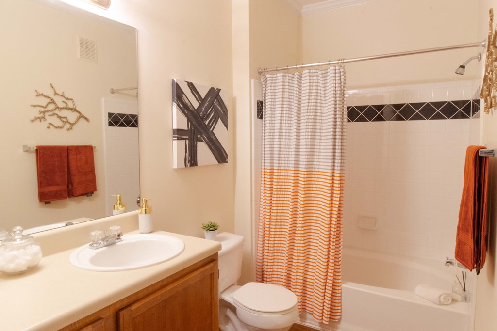 A bathroom with a white sink, toilet, and shower curtain. at The Crest at Sugarloaf, Lawrenceville, Georgia