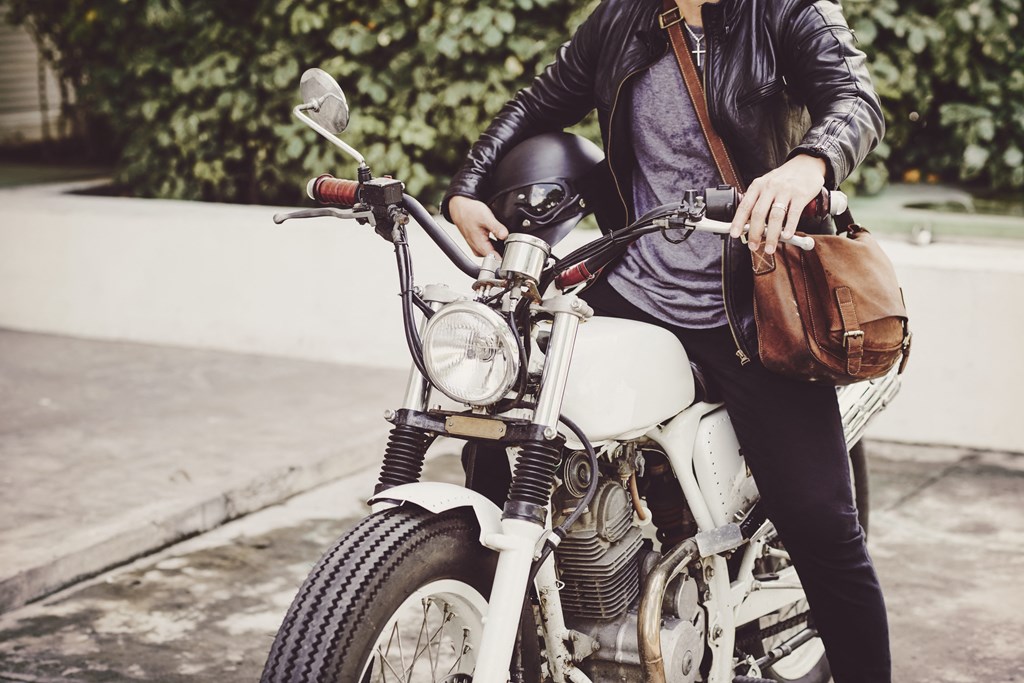 a woman sitting on a motorcycle with a bag at District at Riverside Apartments, Tennessee, 37406