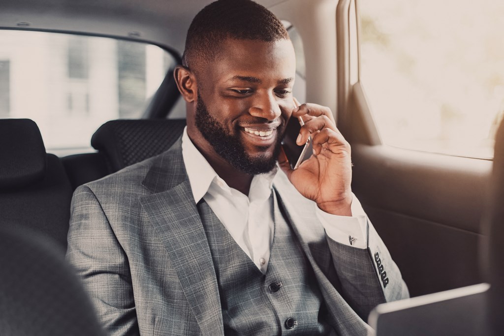 a man in a suit sitting in a car talking on a cell phone at District at Riverside Apartments, Chattanooga, 37406