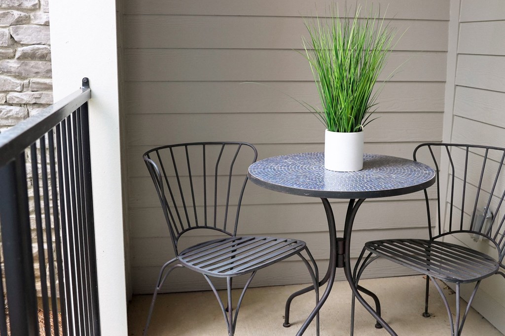 a patio with a table and three chairs
