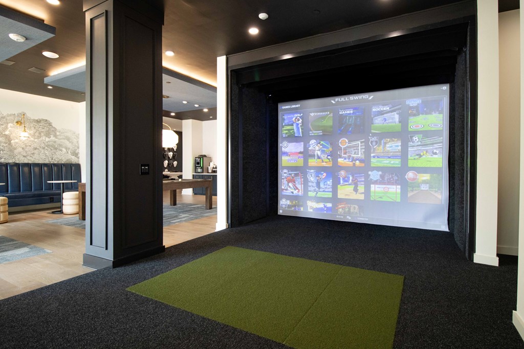 A room with a green carpet and a screen with images on it. at The Crest at South Point Apartments, Georgia, 30253