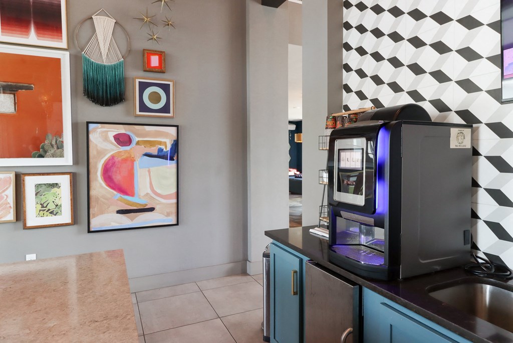 a coffee machine on a counter in a kitchen with art on the wall