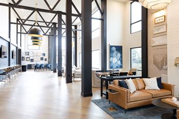 A large room with a couch and a table at The Crest at South Point Apartments, Georgia, 30253