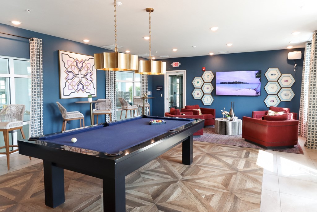 a spacious game room with a pool table and couches