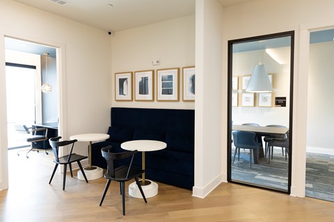 A modern dining room with a black sofa and a white table.