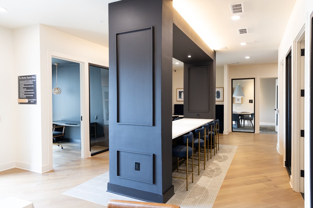 A modern kitchen with a tall dark blue cabinet and a white countertop at The Crest at South Point Apartments, Davenport  30253