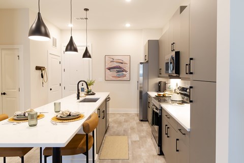 A modern kitchen with a dining table set for two.