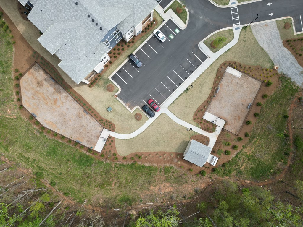 A red car is parked in a parking lot at The Crest at South Point Apartments, Davenport , GA