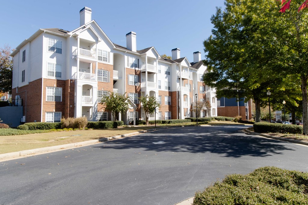 A large apartment complex with a parking lot in front. at The Crest at Sugarloaf, Lawrenceville
