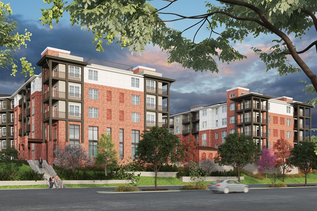 A modern apartment complex with a car driving by.