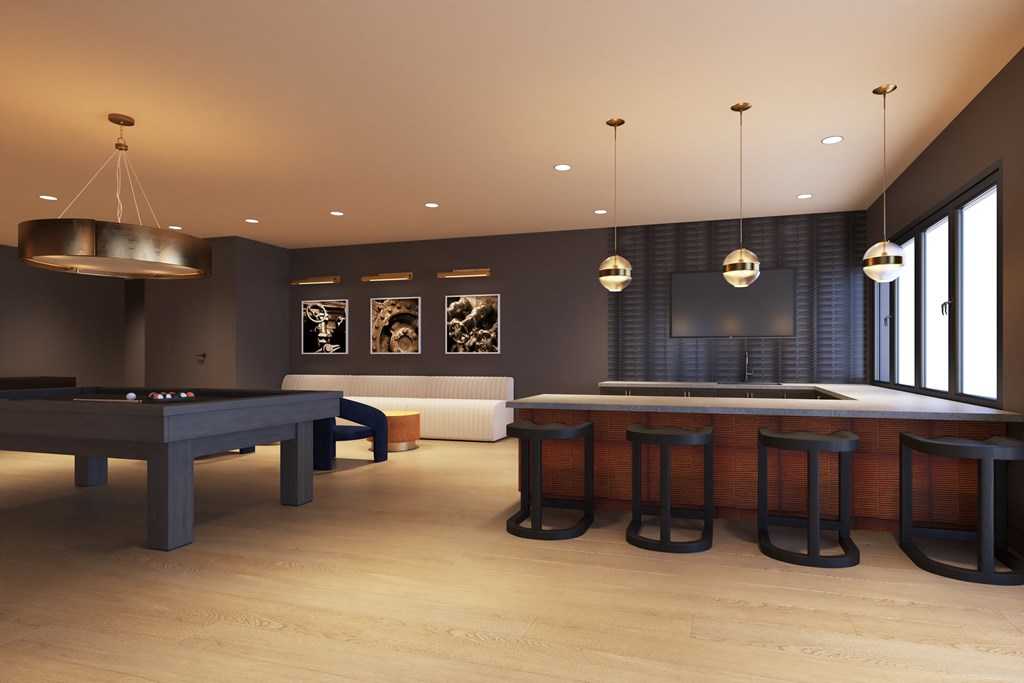 A room with a pool table and bar stools.