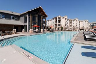 a large swimming pool with apartments in the background