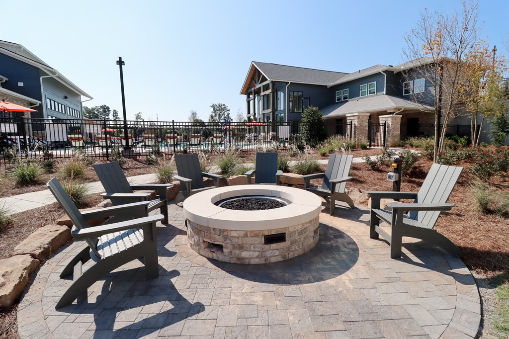 an outdoor fire pit with chairs and a house in the background at The Crest at Acworth, Acworth, GA, 30102