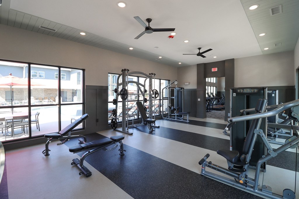 a gym with weights and other exercise equipment and windows at The Crest at Acworth, Georgia, 30102