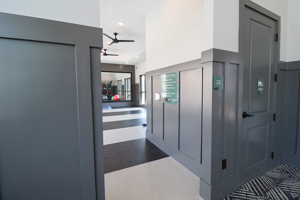 a long hallway with gray doors and a black and white rug and a hall way at The Crest at Acworth, Acworth, 30102