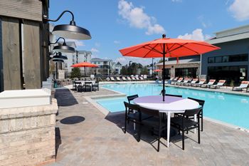 a swimming pool with a table with umbrellas and chairs at The Crest at Acworth, Acworth, GA, 30102