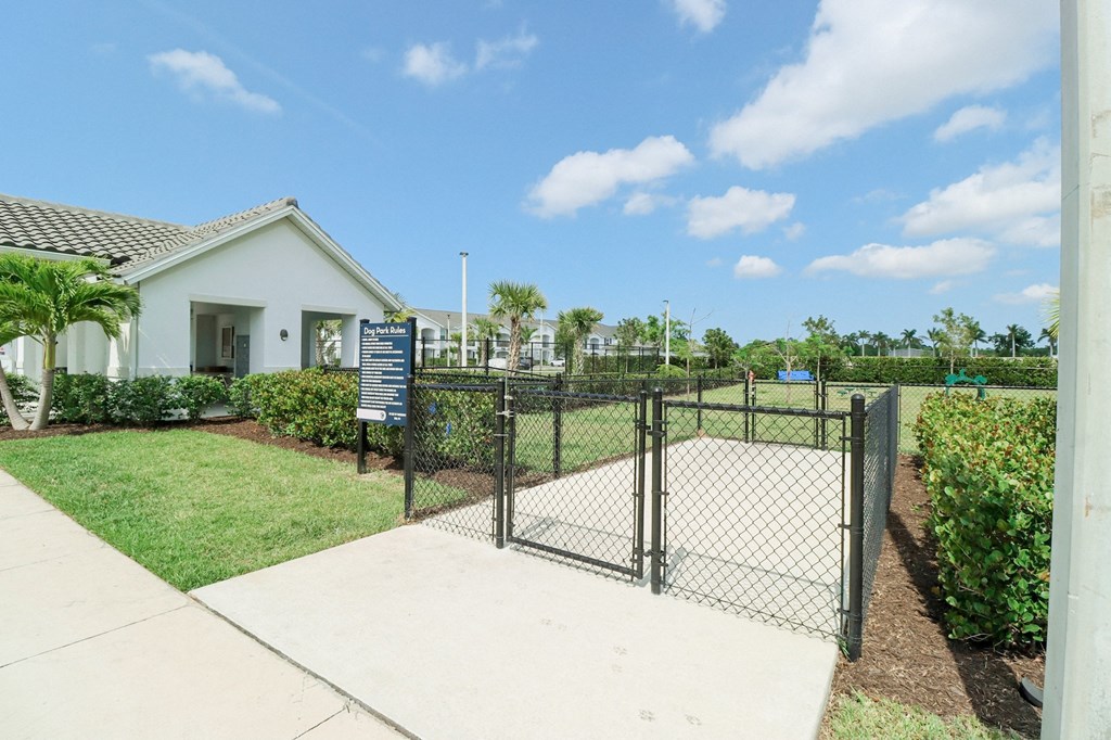 a fenced in yard with a house in the background at The Crest at Naples, Naples, Florida